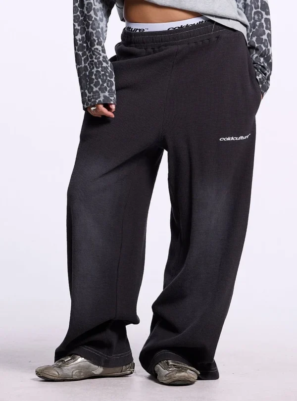 Cold Culture Tropical Waffle Pantalones – Dark Grey – Ajuste frontal Primer plano frontal de los pantalones Tropical Waffle de Cold Culture en gris oscuro, mostrando su ajuste holgado y logotipo blanco