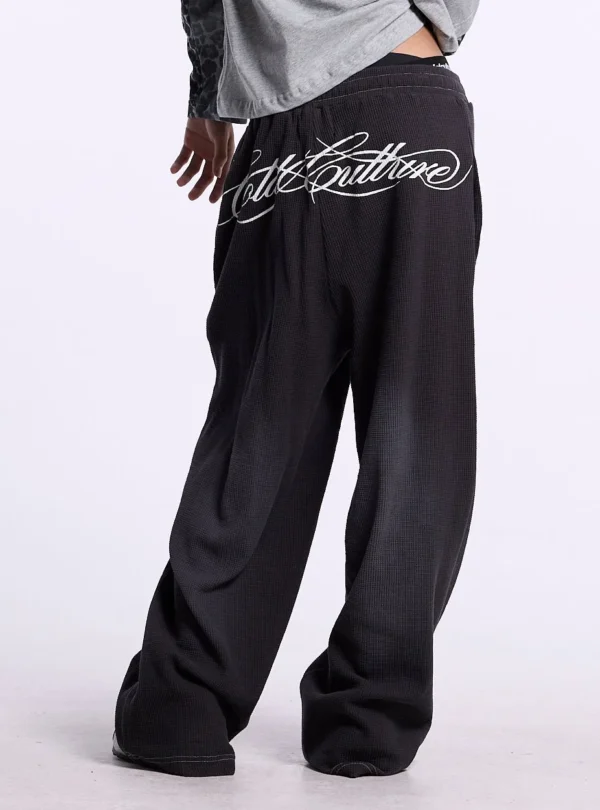 Cold Culture Tropical Waffle Pantalones – Dark Grey – Detalle trasero Detalle trasero de los pantalones Tropical Waffle de Cold Culture en gris oscuro con gran logotipo gráfico blanco