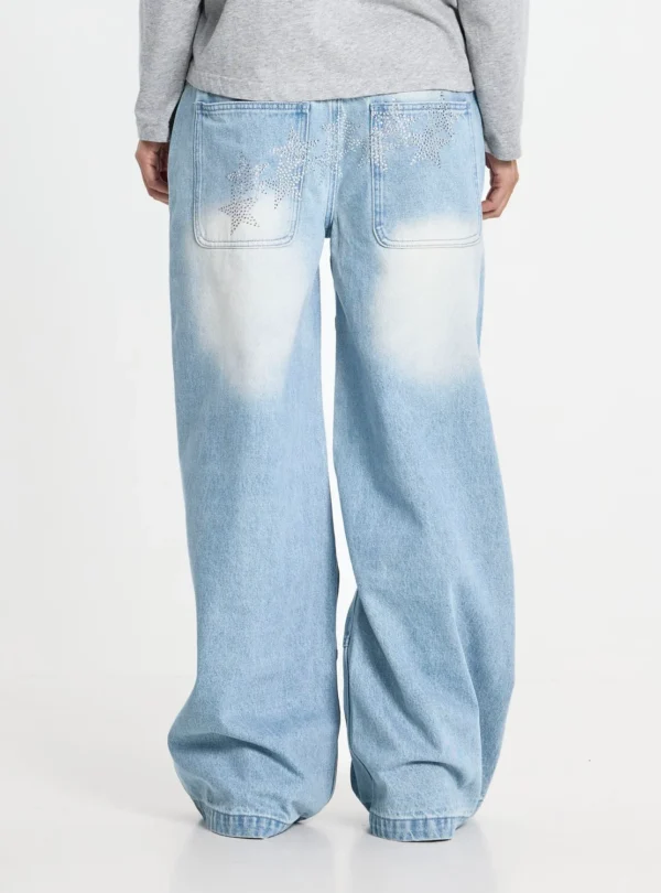 Cold Culture Vera Loose Pantalones Light Blue – Detalle de estrellas traseras Vista trasera de los pantalones Vera Loose Light Blue de Cold Culture puestos en una modelo, destacando las estrellas brillantes en los bolsillos y el corte holgado.