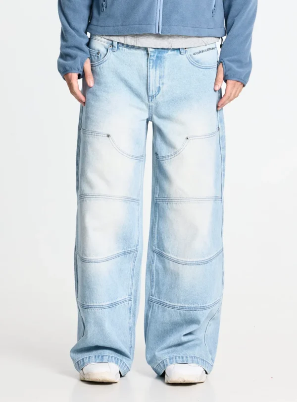 Cold Culture Vera Loose Pantalones Light Blue – Detalle frontal Detalle frontal de los pantalones Vera Loose Light Blue de Cold Culture, con lavado degradado, costuras curvas y horizontales y logotipo junto al bolsillo.