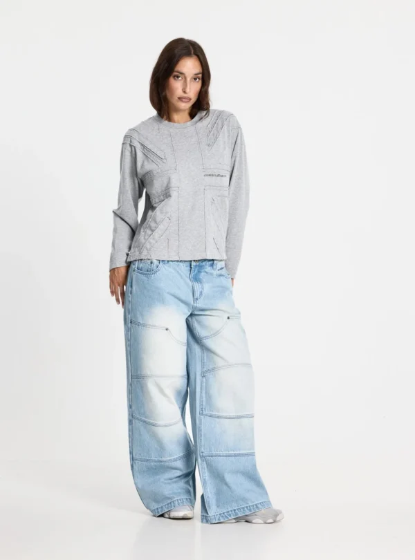 Cold Culture Vera Loose Pantalones Light Blue – Look con modelo femenina Modelo femenina con pantalones vaqueros Vera Loose Light Blue de Cold Culture, de pernera ancha y acabado desgastado, combinados con una sudadera gris.