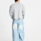 Modelo de espaldas con pantalones Vera Loose Light Blue de Cold Culture, mostrando su silueta ancha, lavado azul claro y bolsillos traseros decorados.