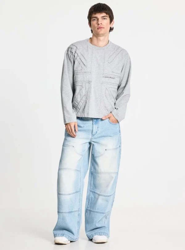 Cold Culture Vera Loose Pantalones Light Blue – Modelo de frente Modelo con pantalones Vera Loose Light Blue de Cold Culture, de corte holgado y perneras anchas, combinados con una sudadera gris y zapatillas blancas.