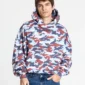 Vista frontal de la sudadera Vertical de Cold Culture en camuflaje azul, rojo y blanco, llevada por un modelo, con capucha, hombros caídos y bolsillo canguro.
