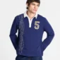 Detalle frontal del polo Windsor Longsleeve Polo Navy de Cold Culture, con cuello blanco, bordado vertical de la marca y parche del número 5 de cuadros.